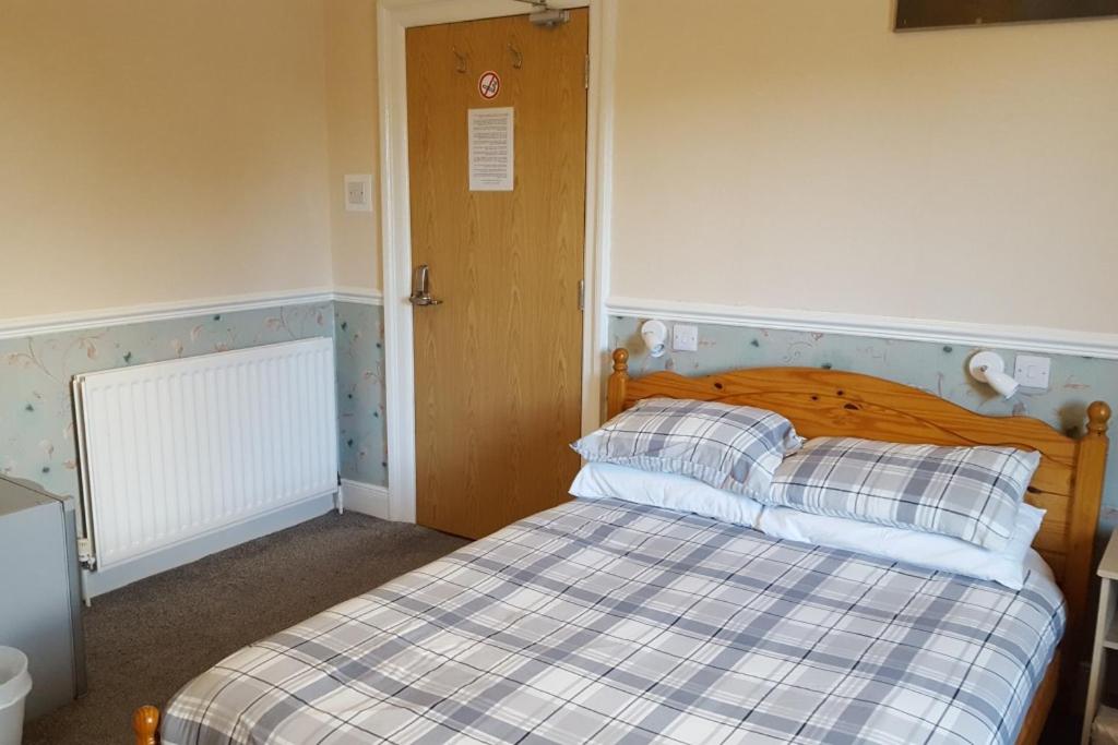 a bedroom with a bed with a checkered blanket at Annie's Accommodation in South Shields