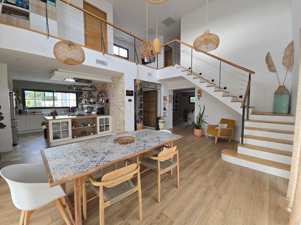 a kitchen and dining room with a table and chairs at Villa Signature in Le Bosc