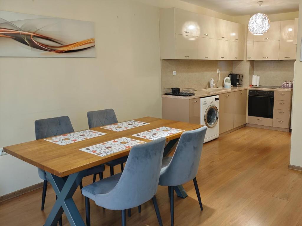 a kitchen with a wooden table and chairs in a room at HostEx Trinity Apartment in Stara Zagora