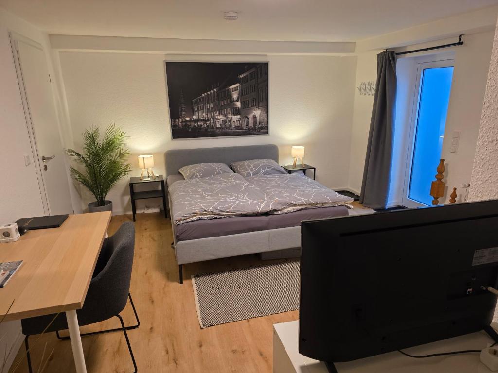 a bedroom with a bed and a desk and a television at Apartment Tanne in Düsseldorf