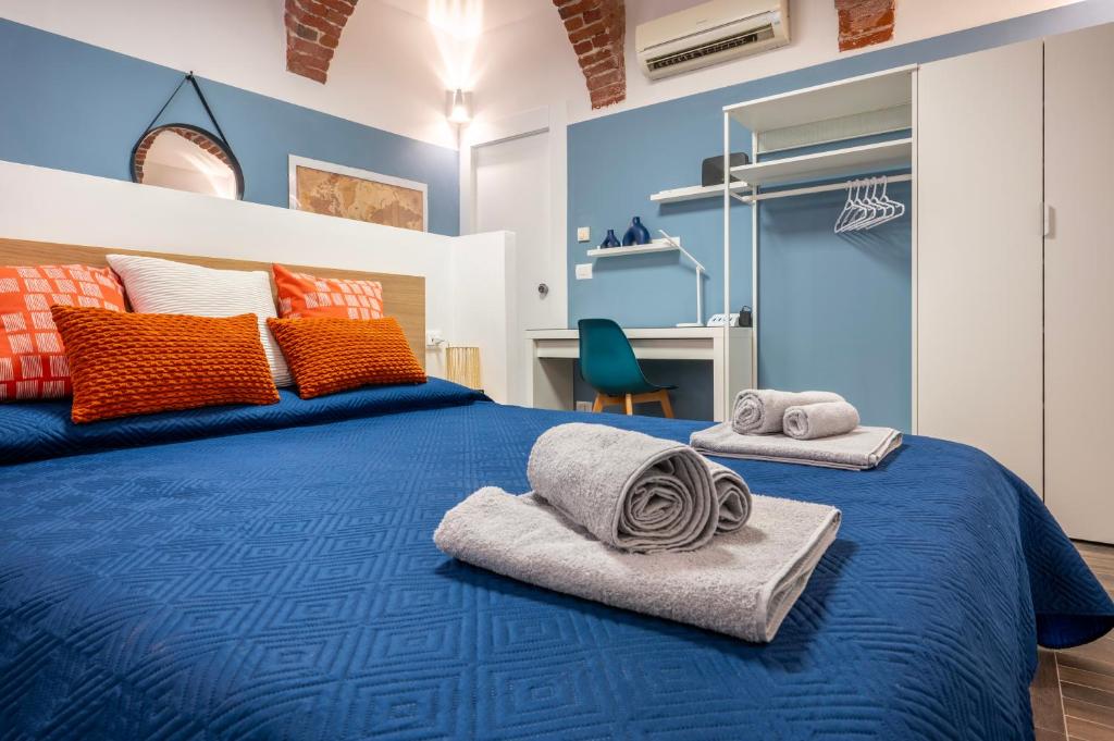 a bedroom with a blue bed with towels on it at BRiKS Airport Stay Caselle in Caselle Torinese