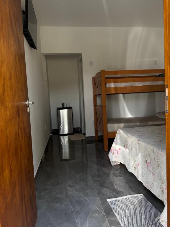 a room with two bunk beds and a door at Pousada e Pesqueiro Recanto do Peixe in Carmo do Rio Claro