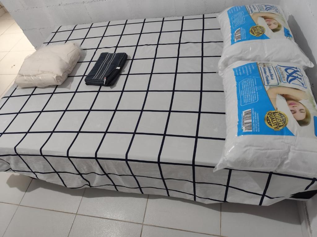 a bed with two bags of food on a tiled floor at Jandira Hosting Acomodação in Jandira