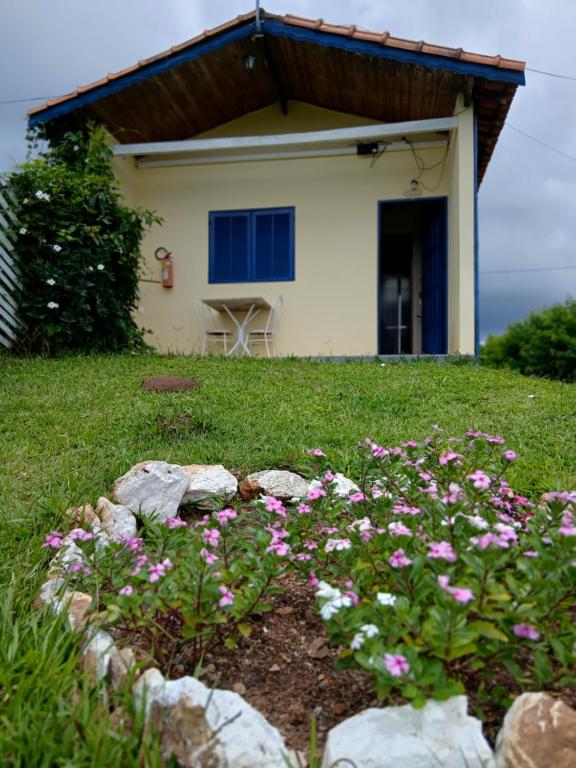 a garden with pink flowers in front of a house at Chalé Romântico in Extrema