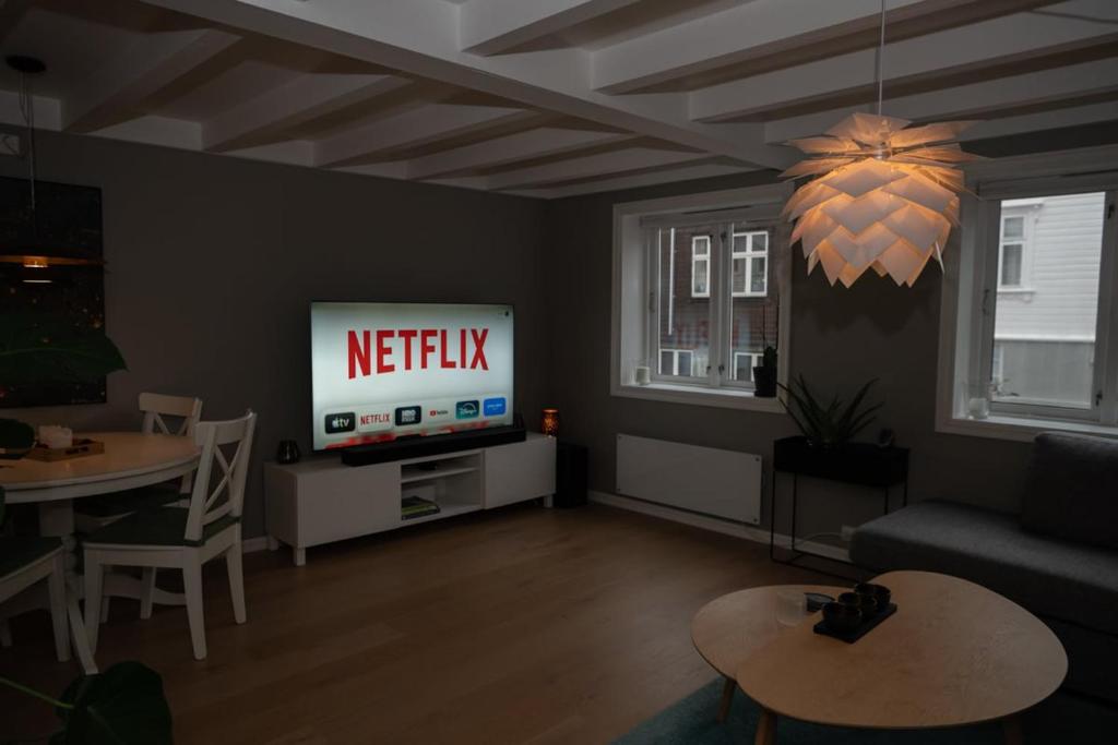 a living room with a television with a netflix sign on it at Classic Stavanger Townhouse, Garden, Spacious in Stavanger