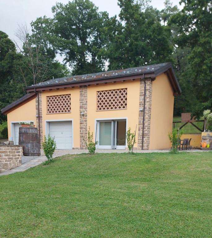 a small yellow house with two garage doors at Santa Croce in Fanano
