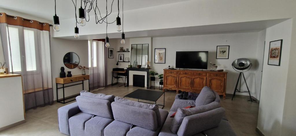 a living room with two couches and a television at Maison Monéteau 6 personnes in Monéteau