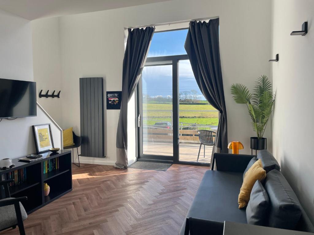 a living room with a couch and a large sliding glass door at School house Portaferry in Portaferry