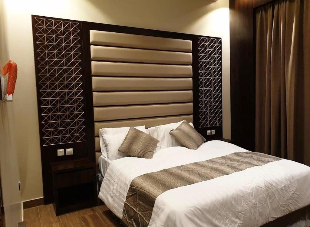 a bedroom with a large bed with a large headboard at اجنحة سبات الفندقيه in Ahad Rafidah
