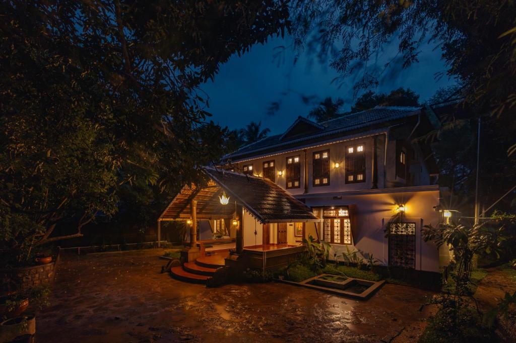 a house lit up at night with lights at The Oneness Living- Seasonal Heritage stay with Tholpaavakoothu nights in Pazhayannūr