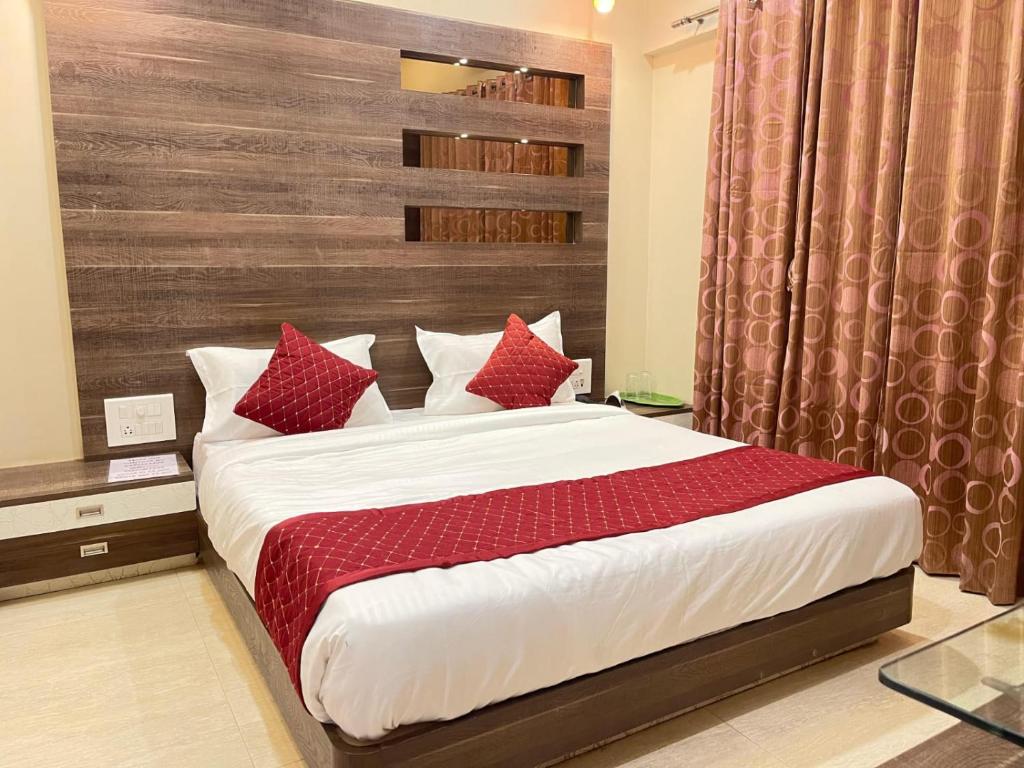a bedroom with a large bed with red pillows at Tejas 4 Bhk Villa in Pune