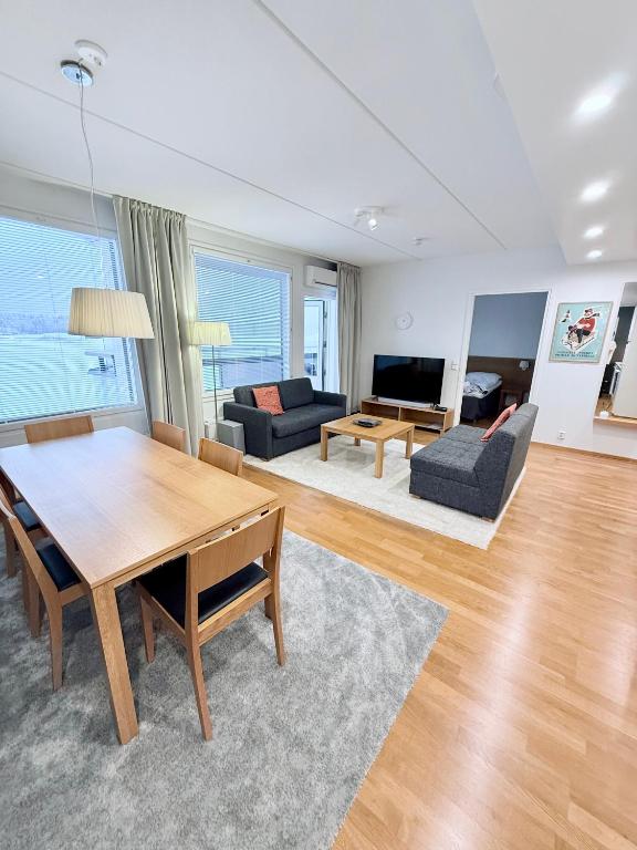 a living room with a table and a couch at Premium Chalet huoneisto kylpylän vieressä in Vierumäki