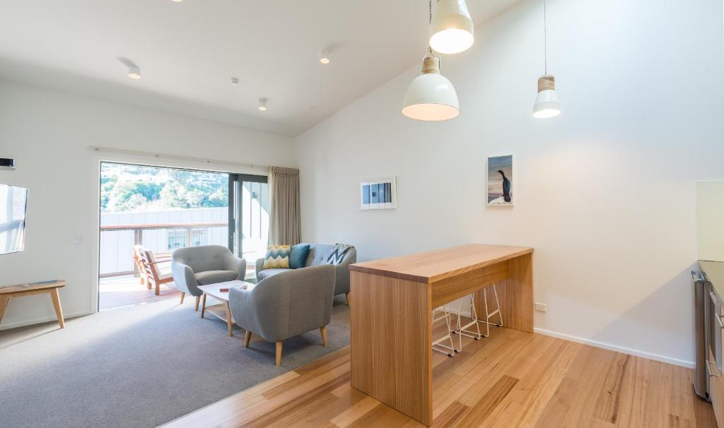 a living room with a table and chairs at Kaiteriteri Reserve Apartments in Kaiteriteri