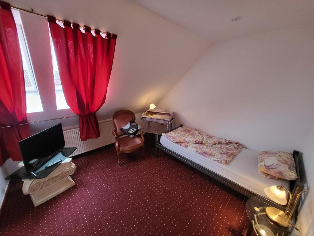 a small room with a bed and a desk and a window at Hotel Schlaun in Nordkirchen