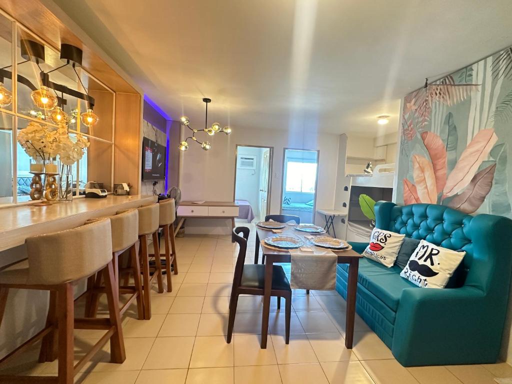a kitchen and dining room with a blue couch and a table at Executive Family Condo Unit in Iloilo City
