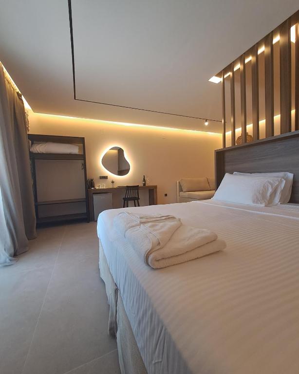 a bedroom with a large white bed with towels on it at Castella Luxe in Loutro