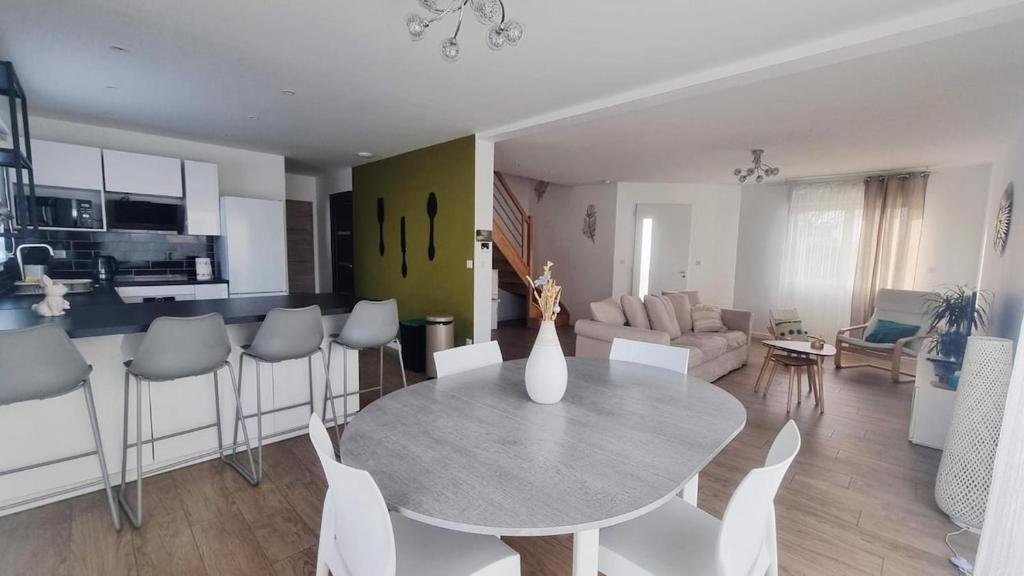 a kitchen and living room with a table and chairs at Superbe Maison avec jardin in Bezannes-les-Reims