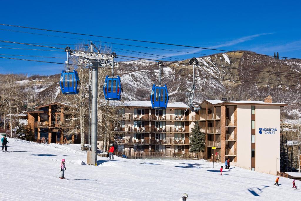 a ski lift in front of a ski resort at Mountain Chalet Snowmass in Snowmass Village