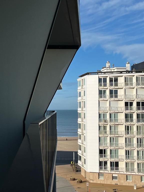 a view of a building and the beach at JuLieze Apartment at Sea & Pool in Ostend