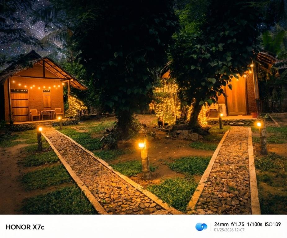 a night view of a house with lights in the yard at Almond Breeze Cottage in Udawalawe