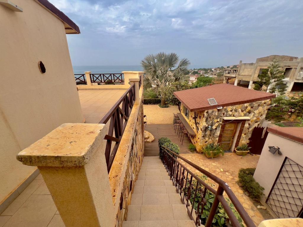 a balcony with a wooden railing and a building at Villa La beauté luxueuse in Rufisque