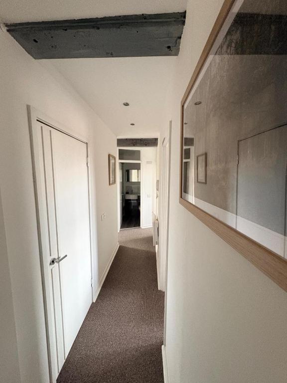 a hallway with a hallway leading into a room with a door at Comfortable Apartment set in an Old Mill in Westbury