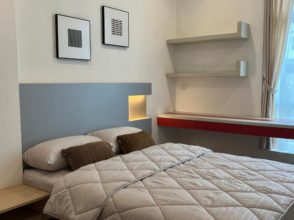 a bedroom with a large bed and a shelf at Leegarden Apartment-3BR in Sibu