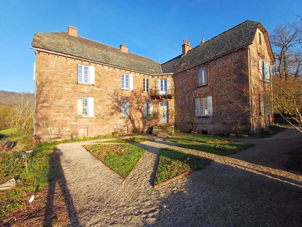 an old brick building with a pathway in front of it at Manoir de Salleviale in Conques-en-Rouergue