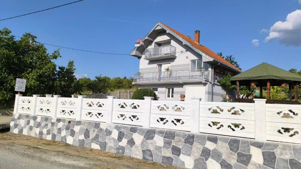 a white fence in front of a house at Domaćinsvo Stević - Sekurič in Belušić