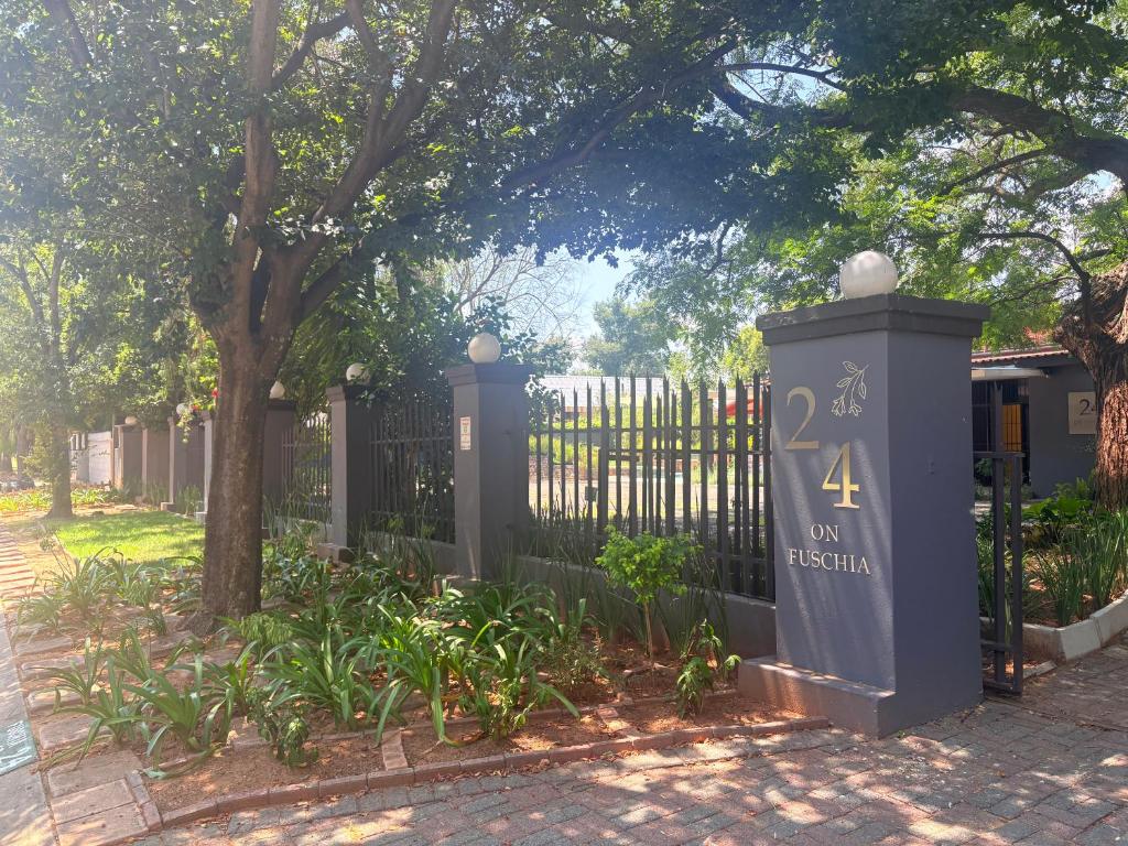 a gate in front of a fence with a tree at 24 on Fuschia in Welkom