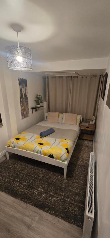 a bedroom with a bed with yellow and white sheets at The Shinki House in Nottingham