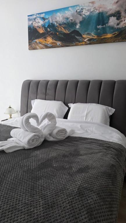 a large bed with a white towel on it at Mountain View Apartment&Parking in Râşnov
