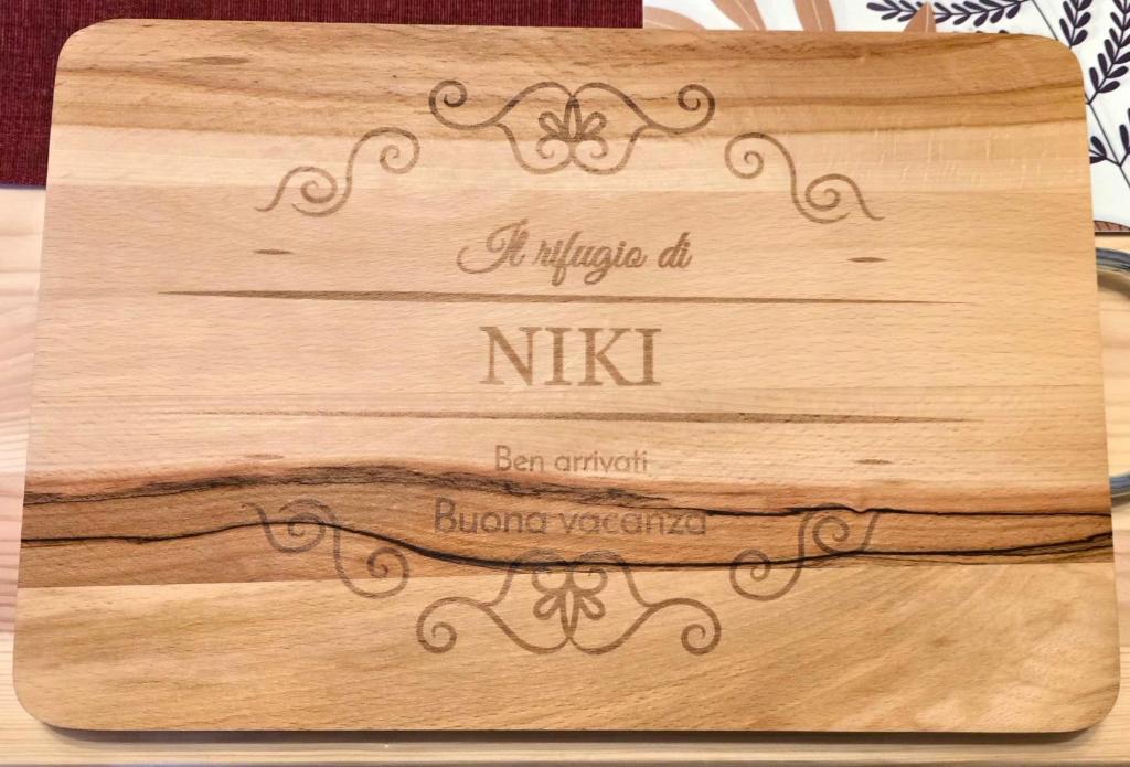 a wooden cutting board with a sign on it at Rifugio di Niki in Falcade