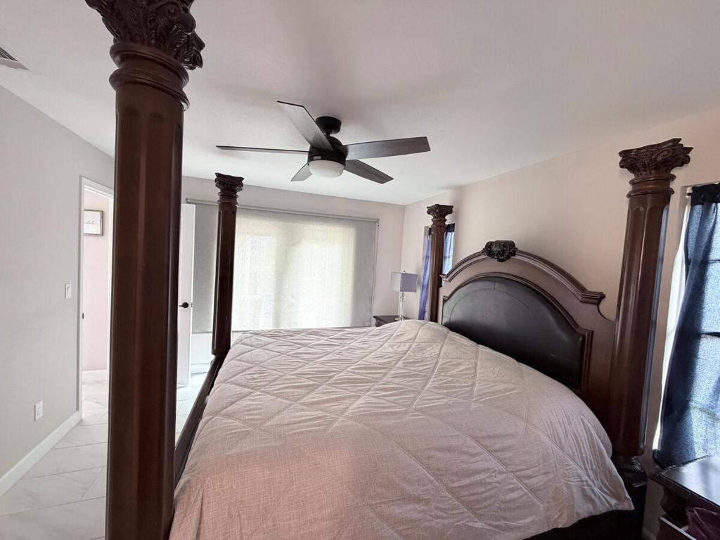a bedroom with a bed with a ceiling fan at Sunshine house on the canal in North Fort Myers