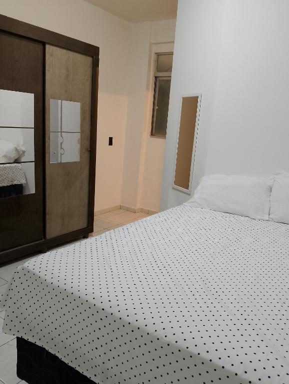 a bedroom with a bed and a wooden cabinet at Kitnet mobiliado a minutos do Parque do Povo in Campina Grande