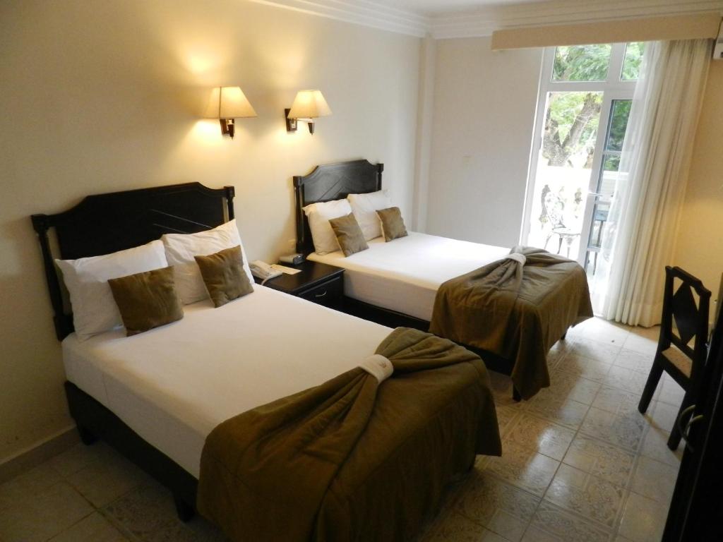 Postel nebo postele na pokoji v ubytování Hotel Victoria Merida