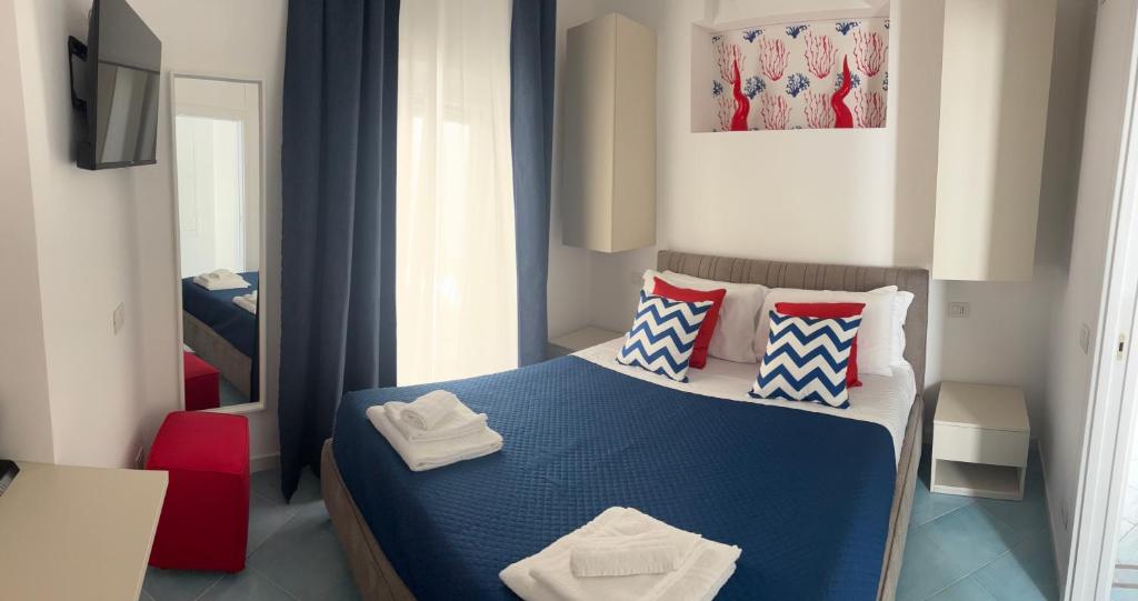 a bedroom with a blue bed and a red chair at D&D Lovely central room in Capri