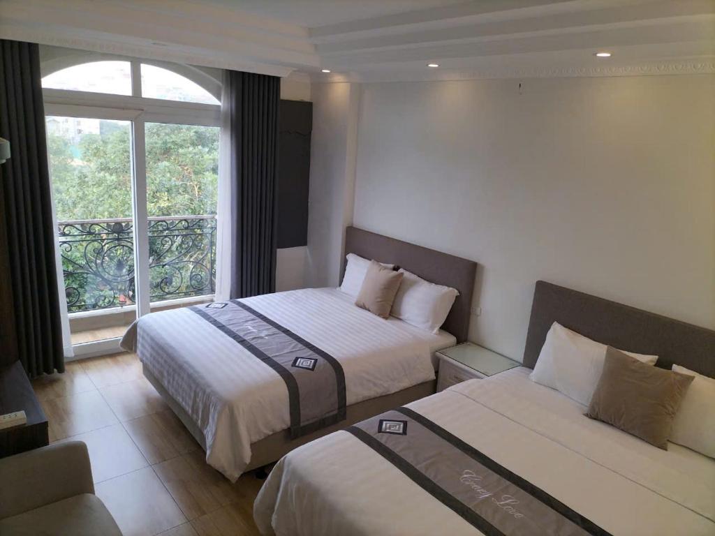 a hotel room with two beds and a window at Sao Mai Cosy Nest-Noi Bai Airport in Thach Loi
