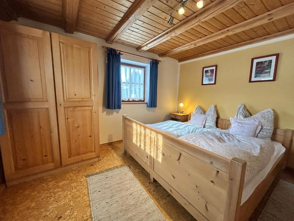 a bedroom with a large wooden bed with pillows at Niedermaier Hof in Bad Birnbach