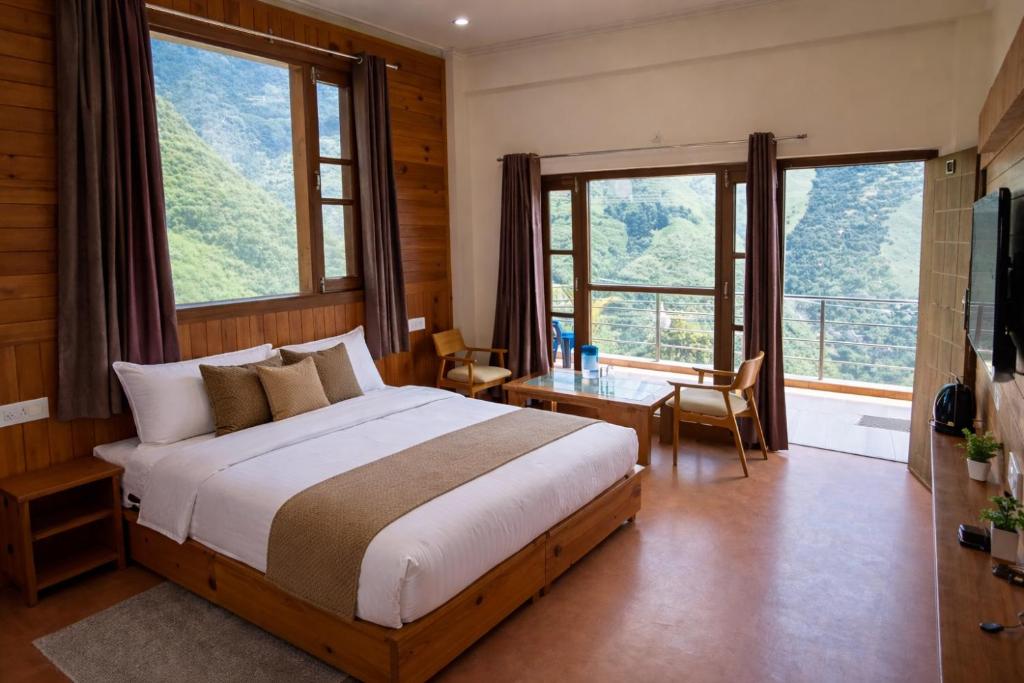 a bedroom with a large bed and large windows at The Tranquil hotel in Chakrāta