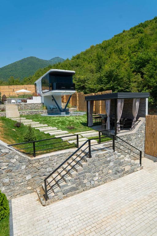 a house with stairs and a building with a hill at Zeyzid Glamping Sheki in Sheki