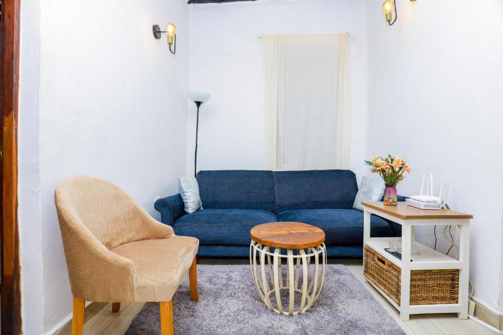 a living room with a blue couch and a table at CoastalCharms Zanzibar in Zanzibar City