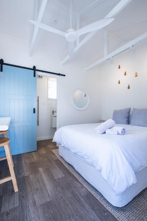 a bedroom with a large white bed and blue cabinets at Small Stays at The Quarters in Turangi
