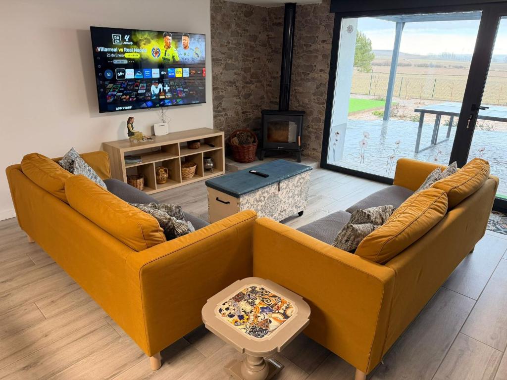 a living room with two couches and a tv at Campos de Villalba in Villalba