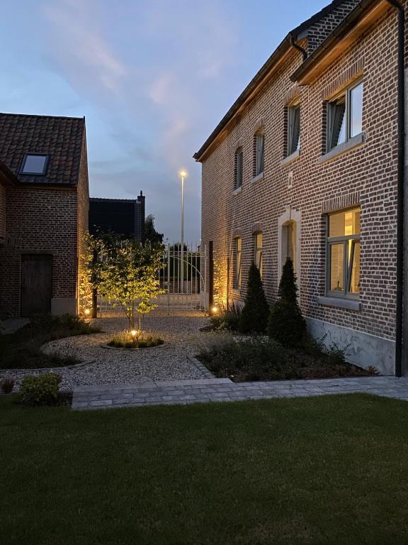 una casa di mattoni con luci davanti di Cièlo a Tongeren