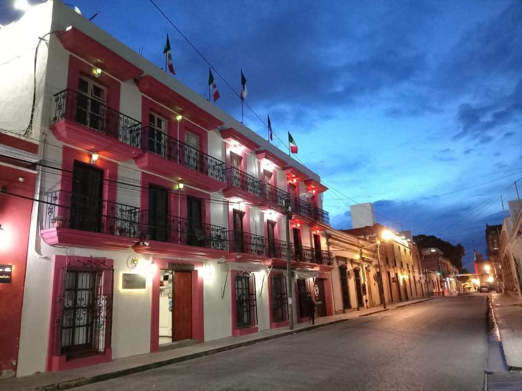 a building with red lights on a street at night at Hotel Mesón del Rey in Oaxaca City
