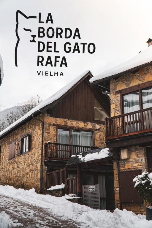 a log cabin in the snow with the words la boedia del gatora at La Borda del Gato Rafa in Vielha