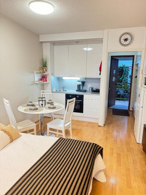 a room with a bed and a table and a kitchen at Kylpylä-hotelli 261 in Ikaalinen