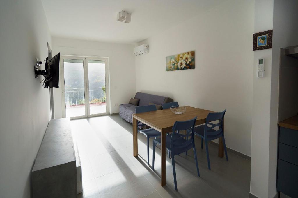 a living room with a wooden table and blue chairs at Il Vecchio Pozzo Apartments in Ostigliano