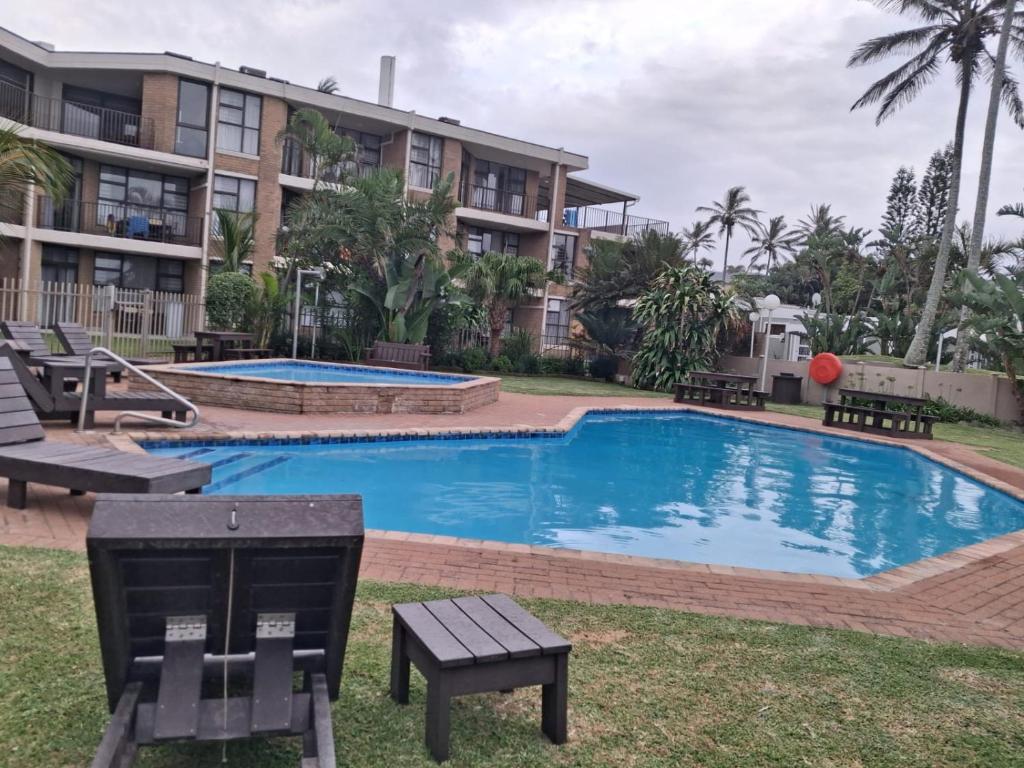 a swimming pool in front of a building at Ocean Breeze 12 Boulder Bay in Ballito